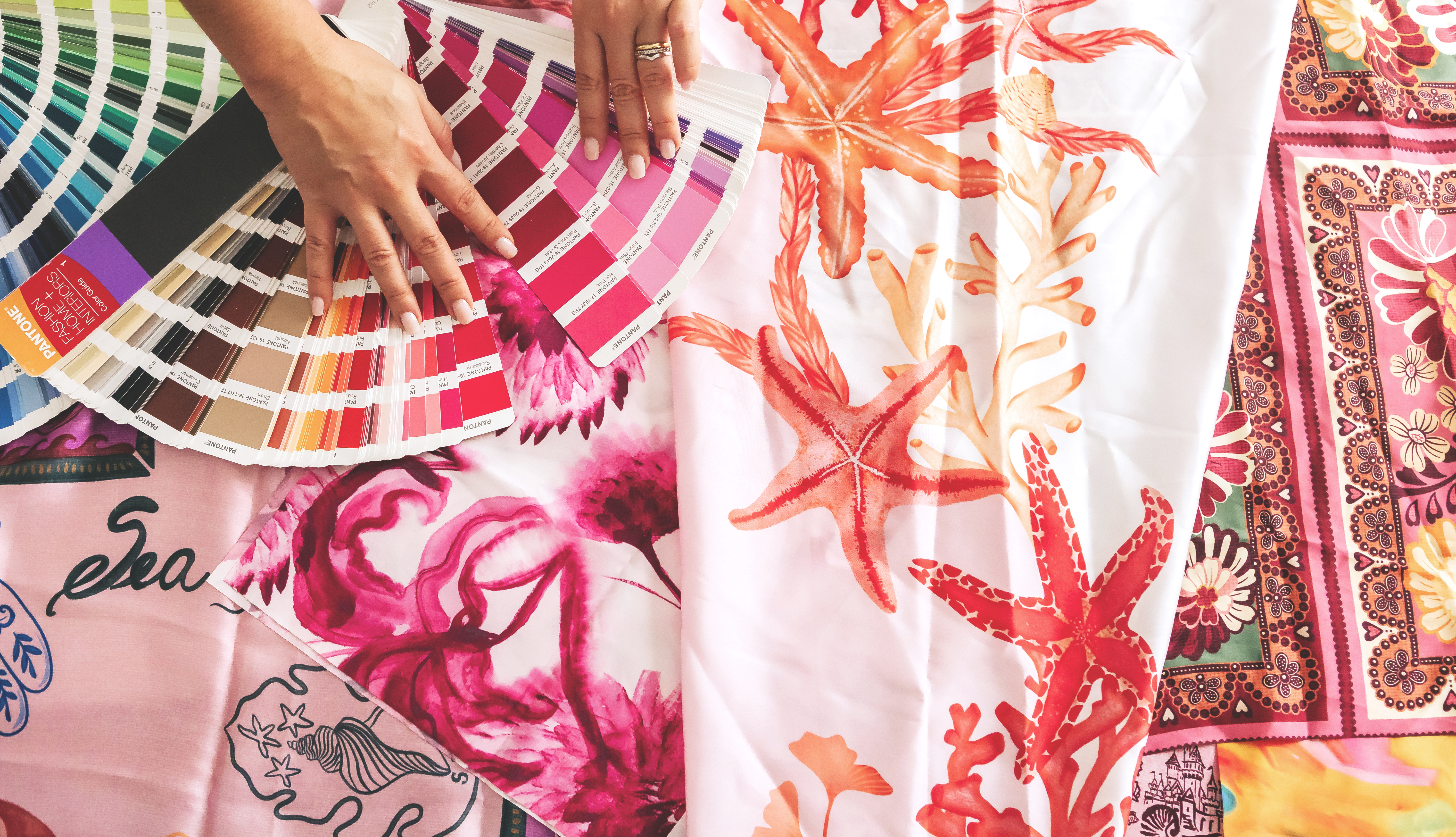 Pantone references laid over printed fabric on the studio table