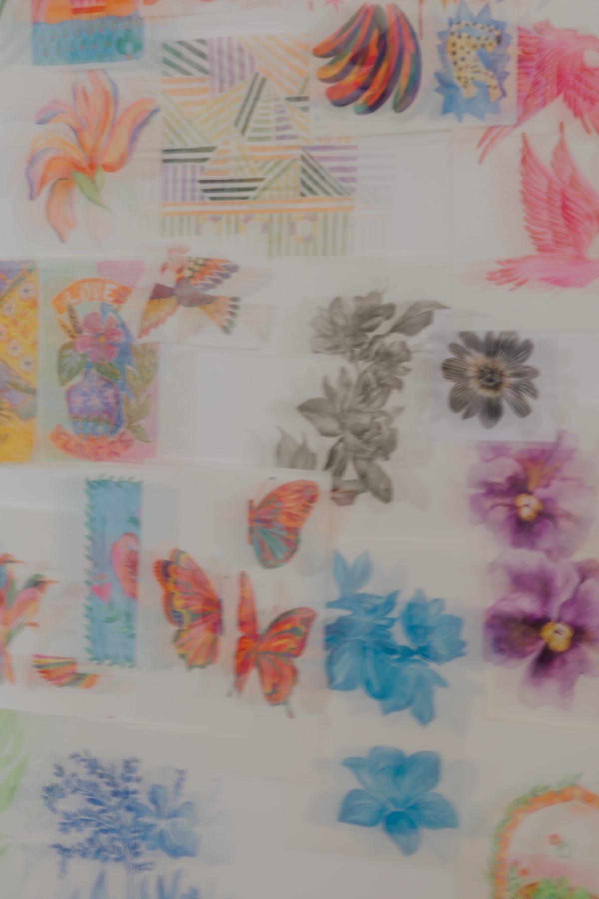 Painted motifs pinned across the studio print wall